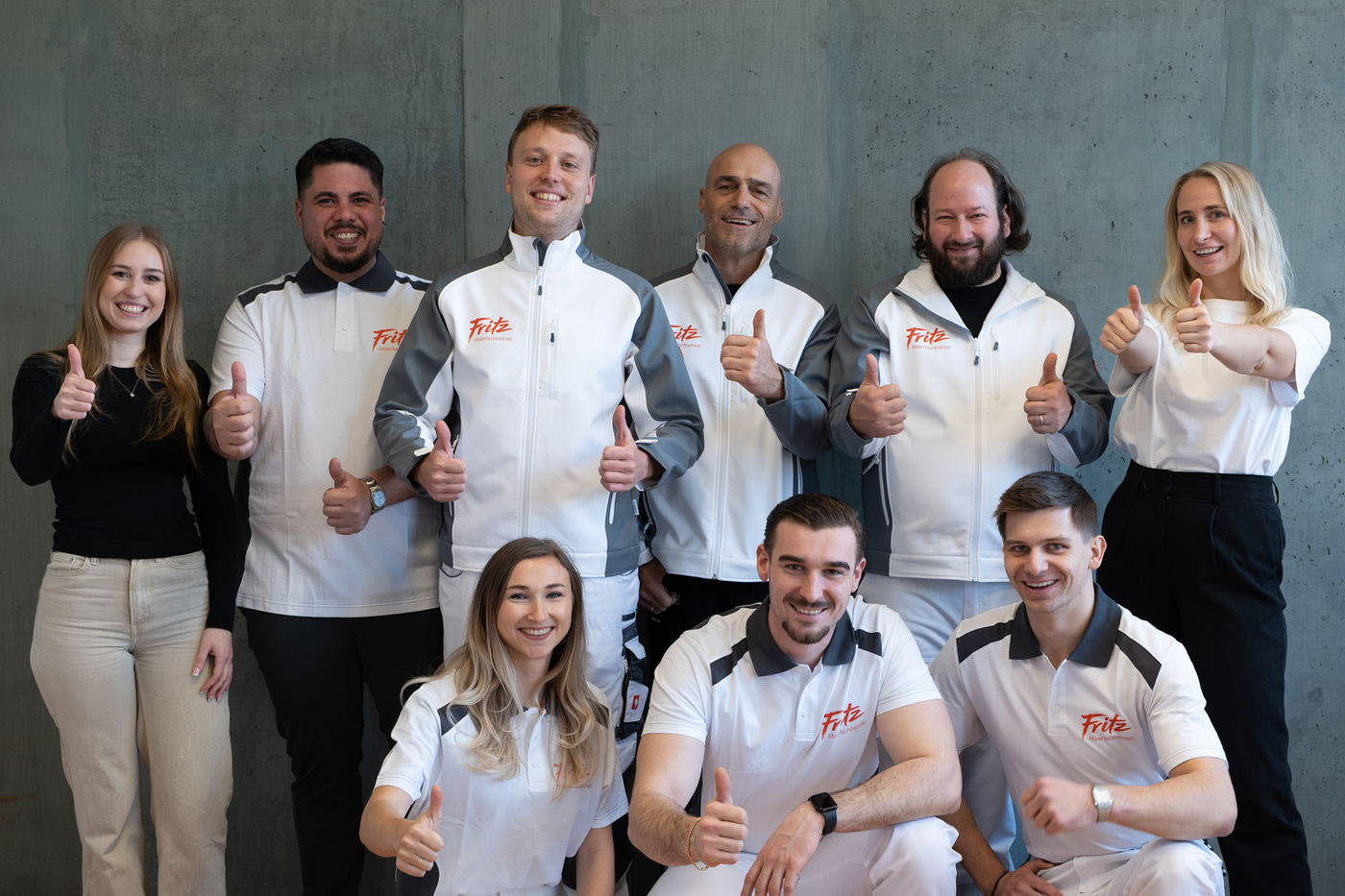 The motivated nine-member Fritz painting company team proudly gives a thumbs-up