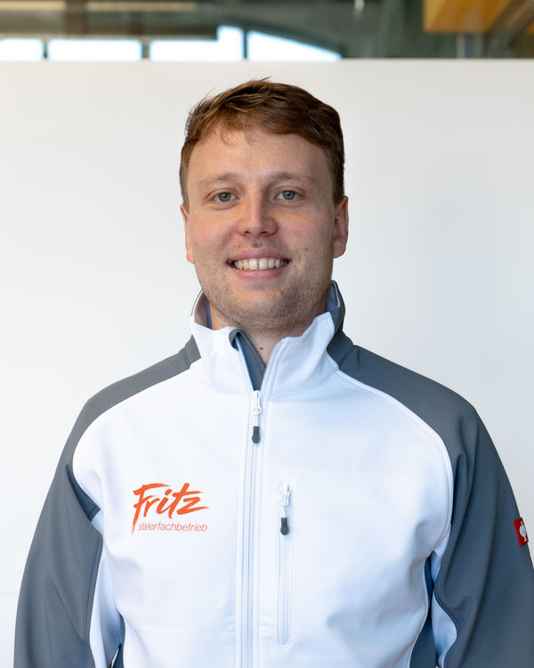 Florian Fritz Vasseur, Managing Director, smiling in the white and grey Fritz painting company softshell jacket
